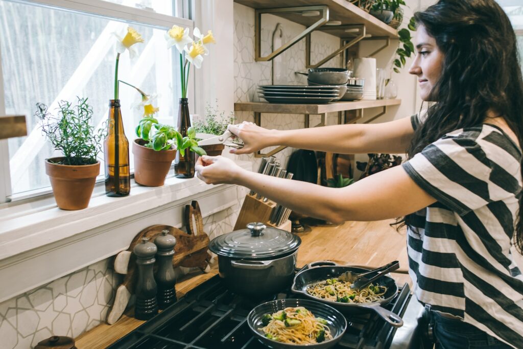 woman cutting herbs for dinner to reach health goals