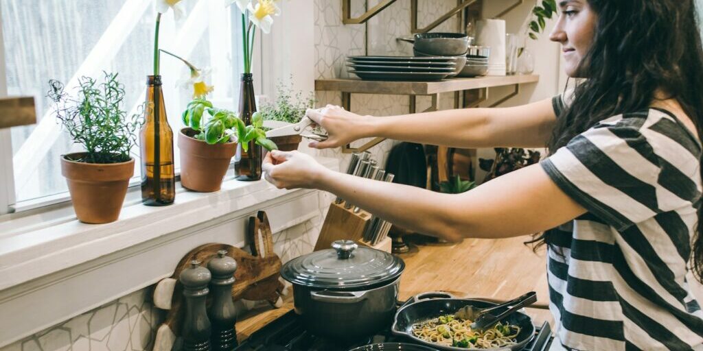 woman cutting herbs for dinner to reach health goals